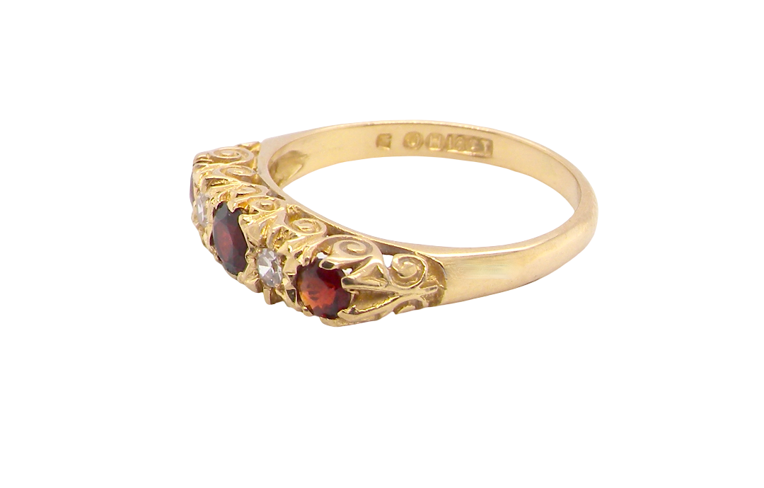A vintage style 18 carat gold boat shaped ring. Features three dark red garnets, centre 4mm, each end a 3mm stone.
side