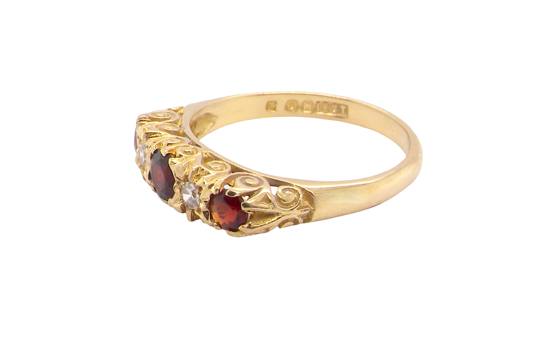 A vintage style 18 carat gold boat shaped ring. Features three dark red garnets, centre 4mm, each end a 3mm stone.
side