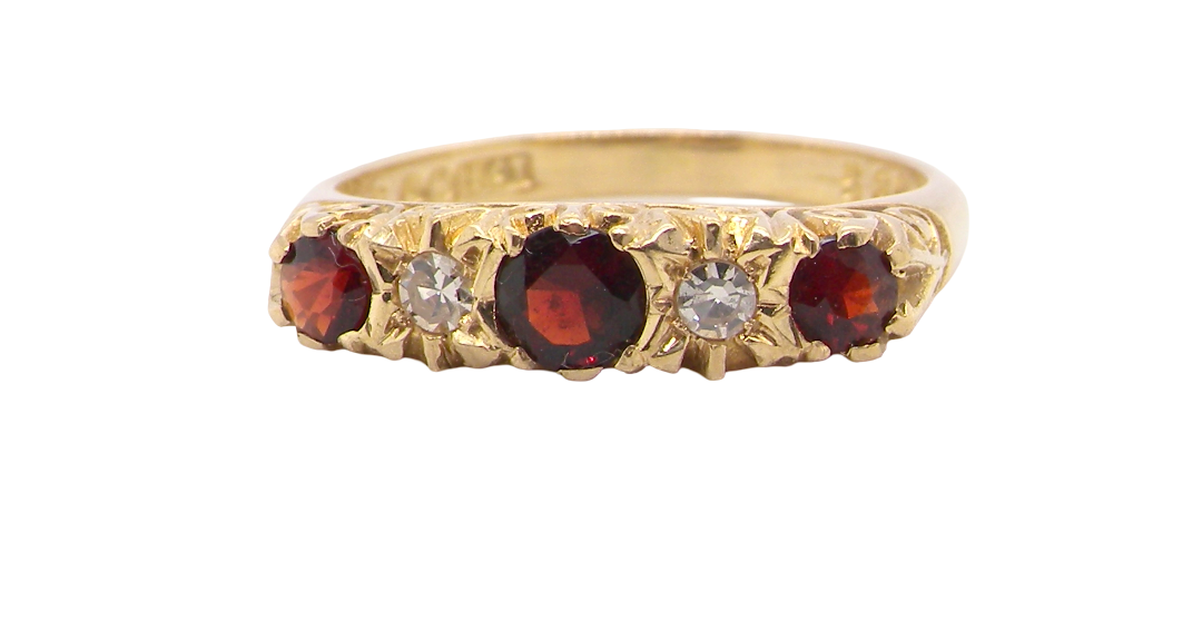 A vintage style 18 carat gold boat shaped ring. Features three dark red garnets, centre 4mm, each end a 3mm stone