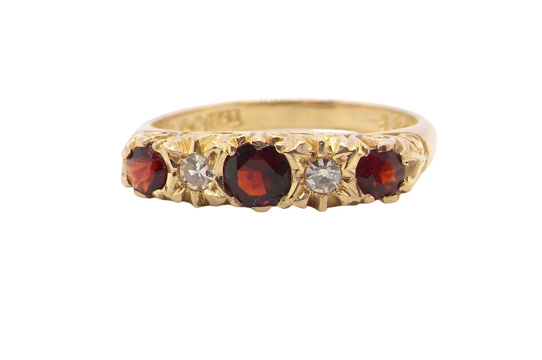 A vintage style 18 carat gold boat shaped ring. Features three dark red garnets, centre 4mm, each end a 3mm stone