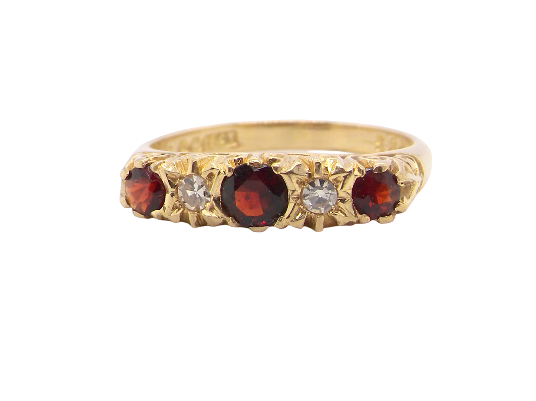 A vintage style 18 carat gold boat shaped ring. Features three dark red garnets, centre 4mm, each end a 3mm stone