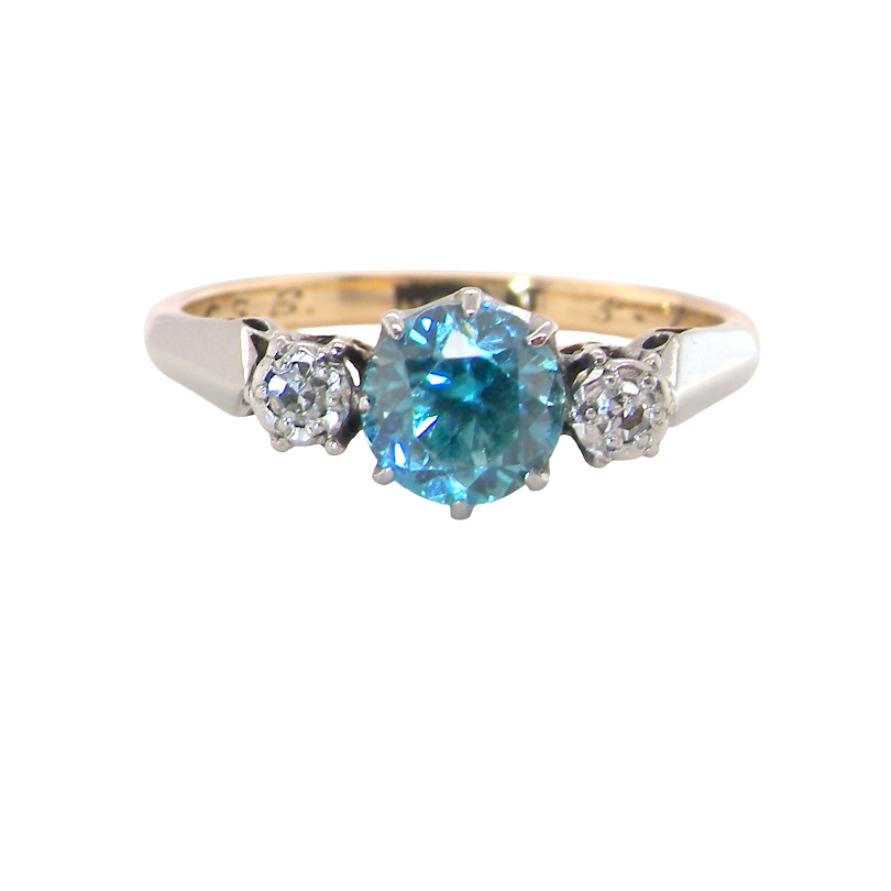 A vintage three stone ring. Features to the centre a 6mm natural blue zircon, 6mm diameter,