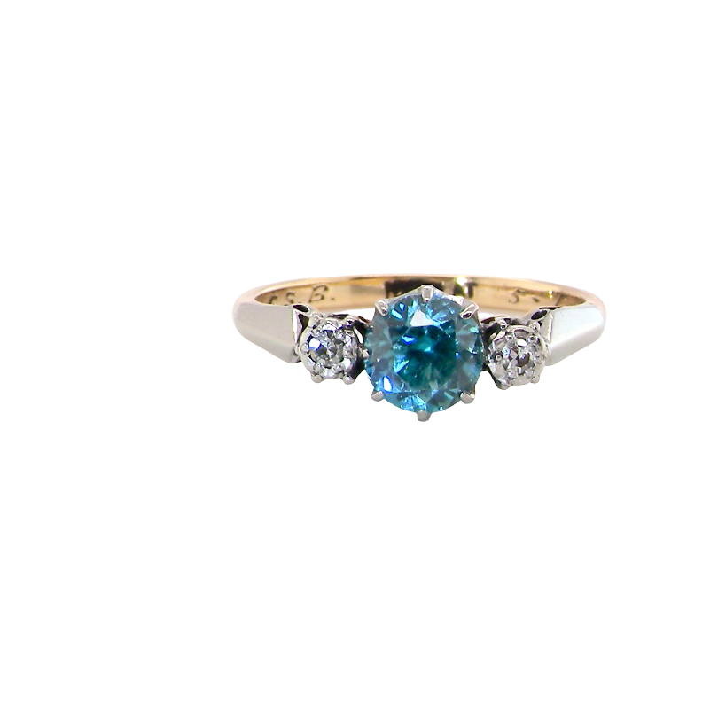 A vintage three stone ring. Features to the centre a 6mm natural blue zircon, 6mm diameter, claw set.
