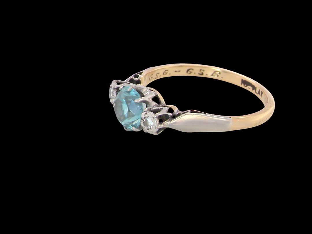 A vintage three stone ring. Features to the centre a 6mm natural blue zircon, 6mm diameter, claw set.side