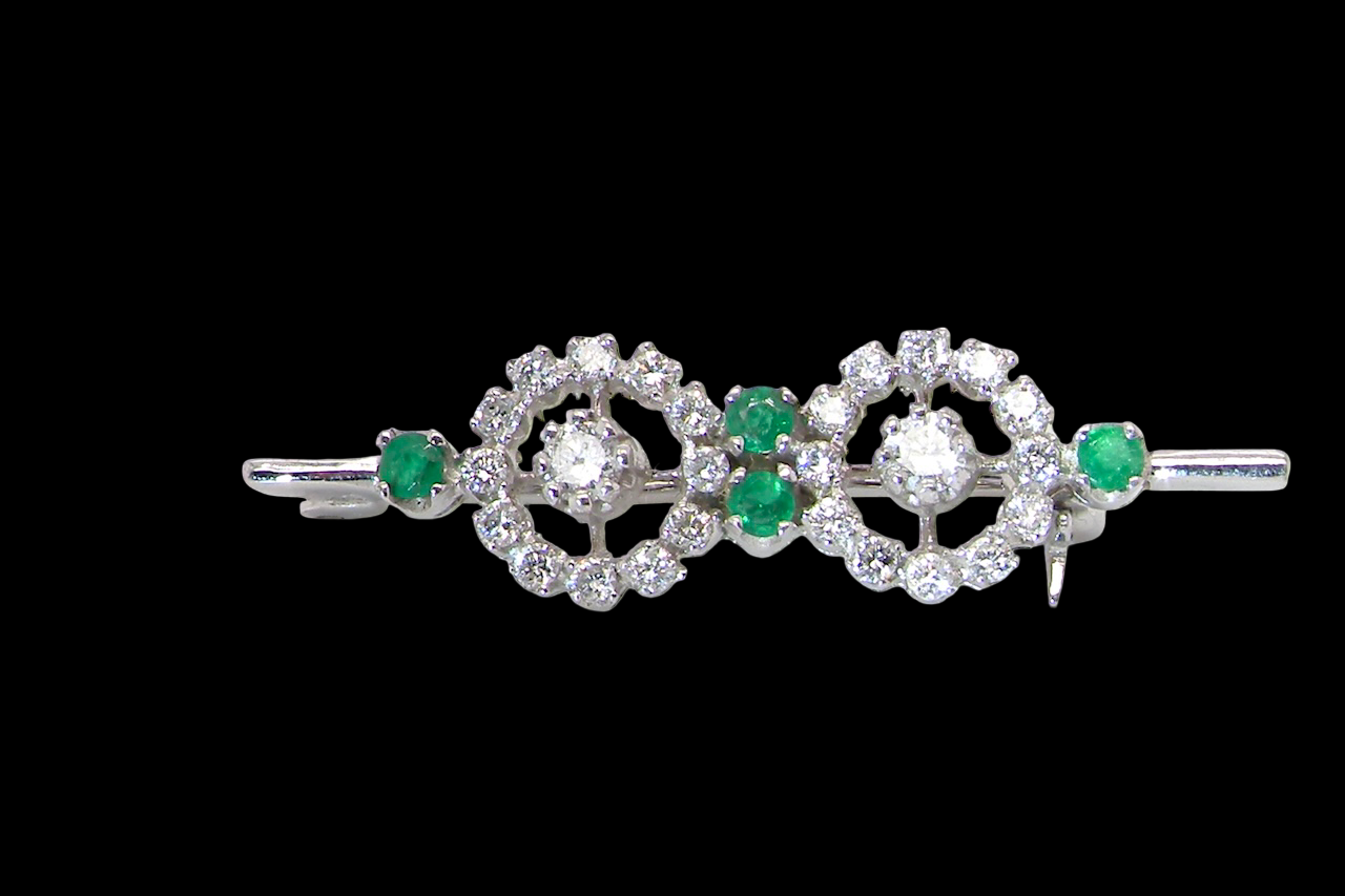 A wearable brooch. A double cluster of brilliant cut white diamonds, each set to the centre with an 0.10 carat stone and surrounded by twelve x 0.015 carat stones*. Total carat weight estimated at 0.60 carats*