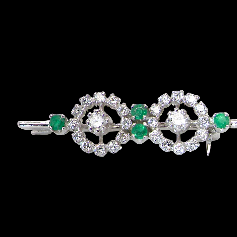 A wearable brooch. A double cluster of brilliant cut white diamonds, each set to the centre with an 0.10 carat stone and surrounded by twelve x 0.015 carat stones*. Total carat weight estimated at 0.60 carats*