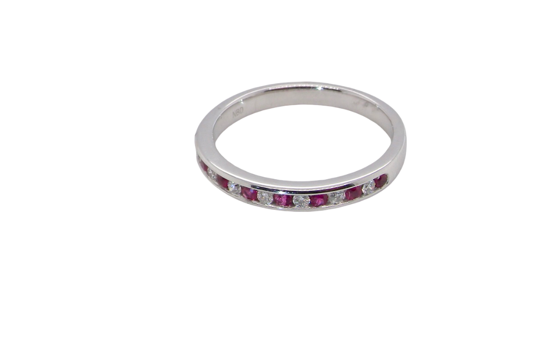 A white gold half hoop eternity ring. Set with seven round rubies and six brilliant cut white diamonds new