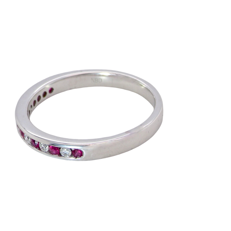 A white gold half hoop eternity ring. Set with seven round rubies and six brilliant cut white diamonds side