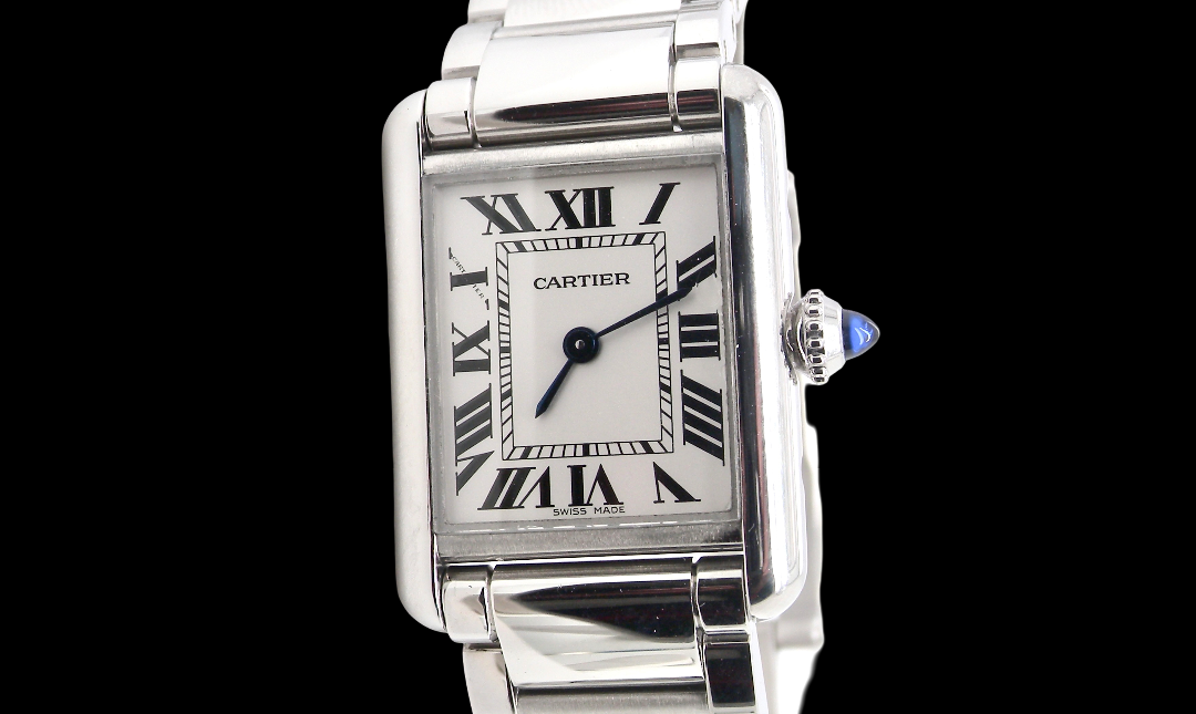 A womans stainless steel Cartier Tank Must wrist watch. Model number WSTA0051.
Silver coloured dial with Roman Numerals. Blue steeled hands. Case measures 29.5x22mm, case thickness 6.6mm. Quartz movement,