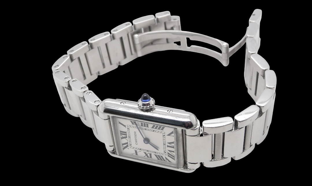 A womans stainless steel Cartier Tank Must wrist watch. Model number WSTA0051.
Silver coloured dial with Roman Numerals. Blue steeled hands. Case measures 29.5x22mm, case thickness 6.6mm. Quartz movement, synthetic sapphire button.
side