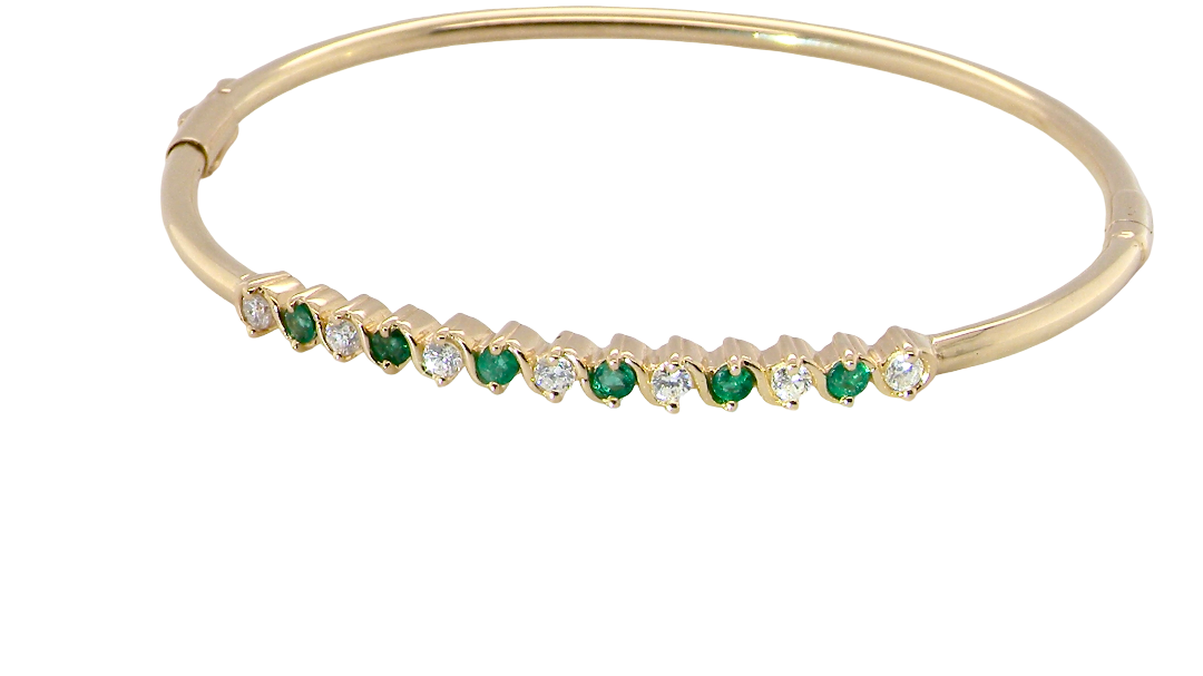 A yellow gold bangle. Features alternate emeralds and diamonds. Six 2.7mm emeralds and seven brilliant cut white diamonds, each 2.7mm (total diamond total 0.50 carats)