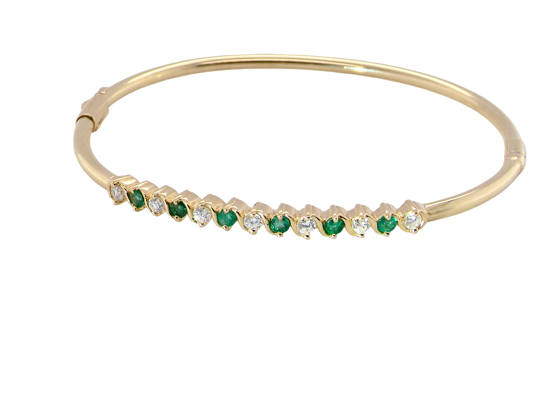 A yellow gold bangle. Features alternate emeralds and diamonds. Six 2.7mm emeralds and seven brilliant cut white diamonds, each 2.7mm (total diamond total 0.50 carats)