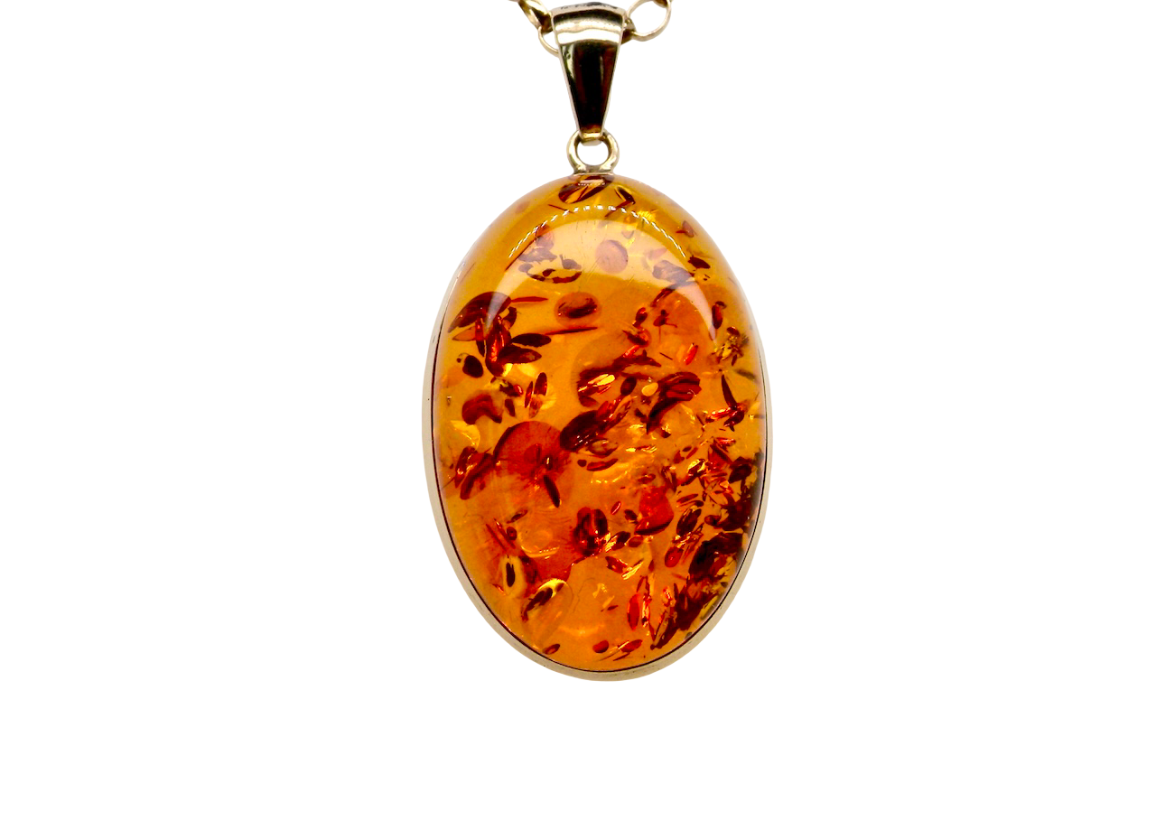 Amber pendant on a gold chain against a white background