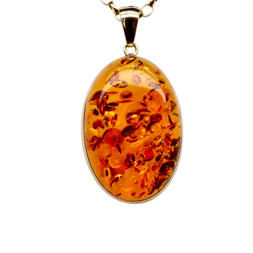 Amber pendant on a gold chain against a white background