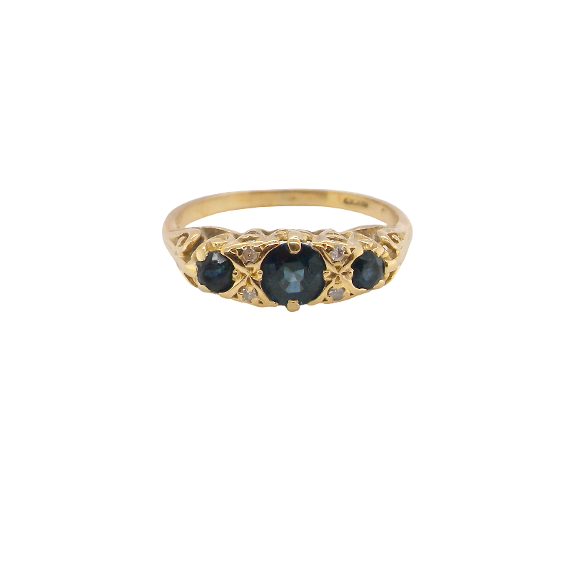 An 18 carat* boat shaped ring. Features three dark inky blue sapphires, centre 4.7mm, each end a 3mm stone.