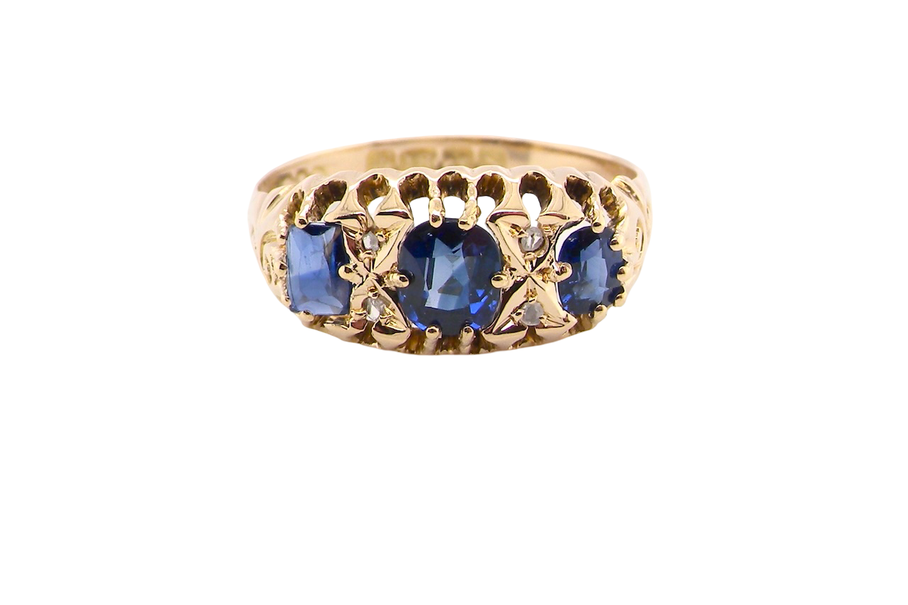 An 18 carat gold antique boat shaped ring. Features three oval to cushion cut sapphires, centre 6x5mm,