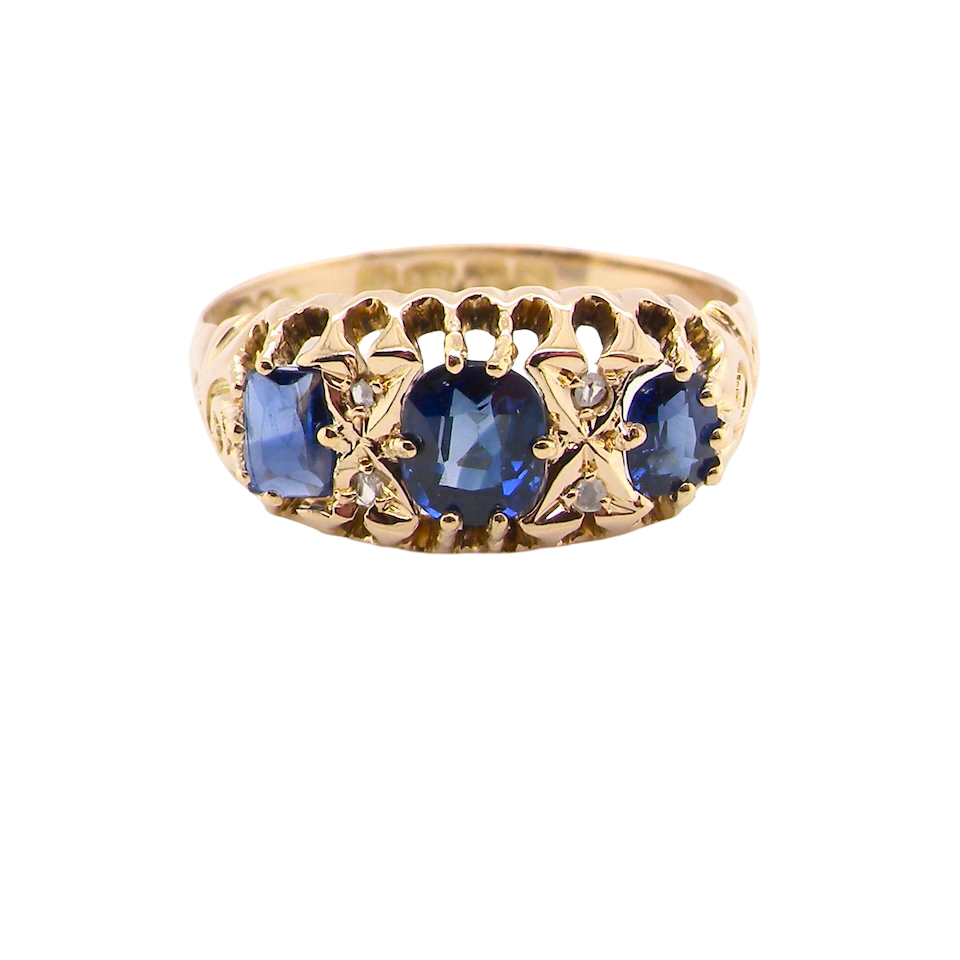 An 18 carat gold antique boat shaped ring. Features three oval to cushion cut sapphires, centre 6x5mm,