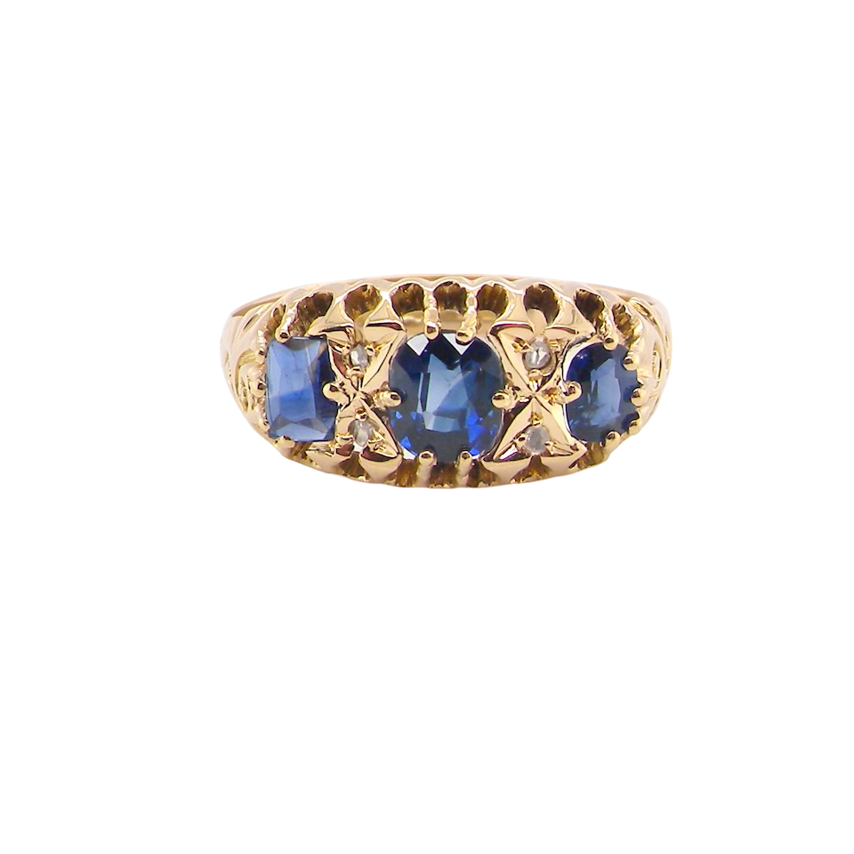 An 18 carat gold antique boat shaped ring. Features three oval to cushion cut sapphires, centre 6x5mm, each end 5x3mm. Mid to dark blue