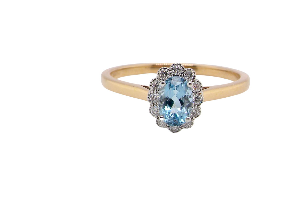 An 18 carat gold cluster ring. Set to the centre a lovely ice blue aquamarine 6x4mm,