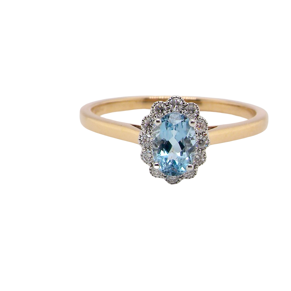 An 18 carat gold cluster ring. Set to the centre a lovely ice blue aquamarine 6x4mm,