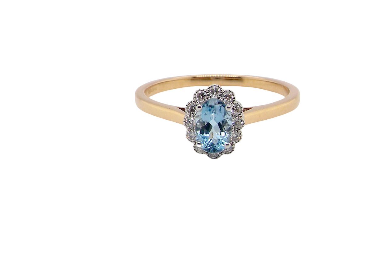 An 18 carat gold cluster ring. Set to the centre a lovely ice blue aquamarine 6x4mm, claw set.