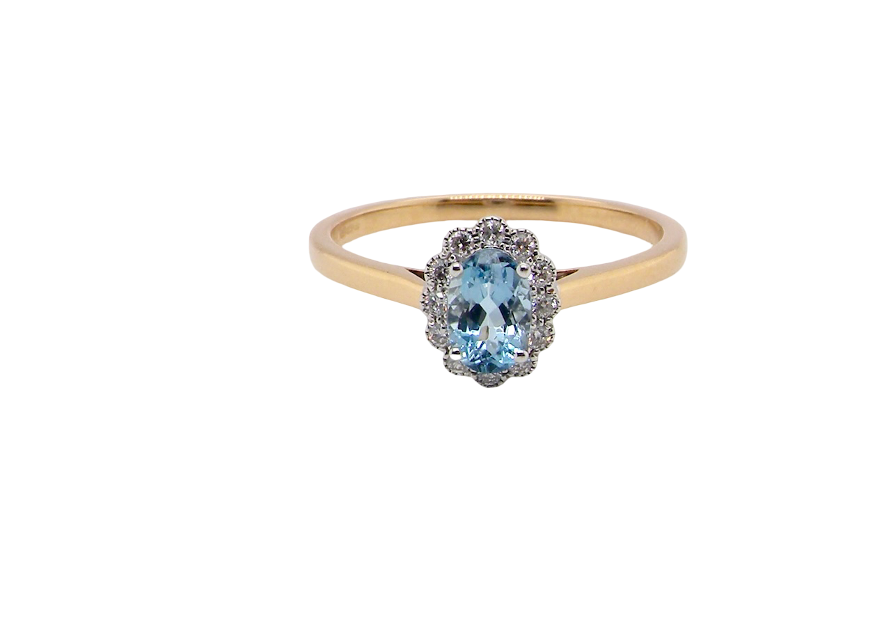 An 18 carat gold cluster ring. Set to the centre a lovely ice blue aquamarine 6x4mm, claw set.