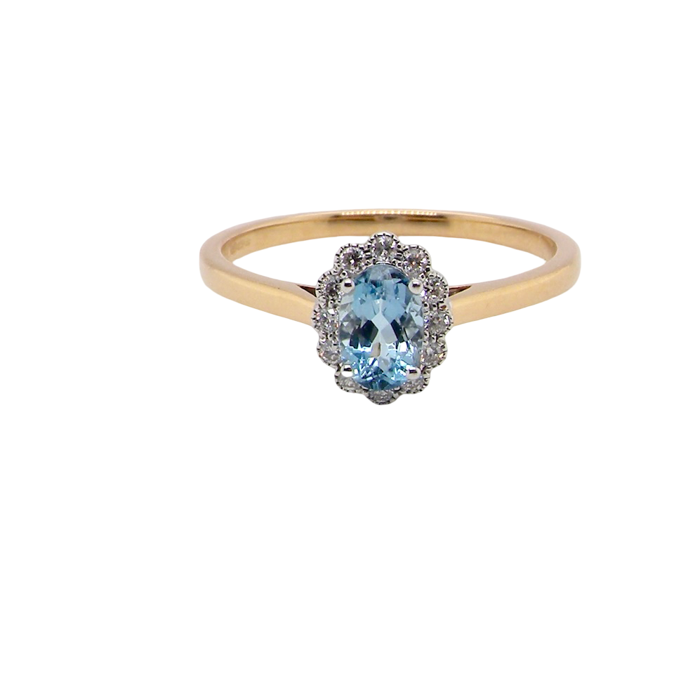 An 18 carat gold cluster ring. Set to the centre a lovely ice blue aquamarine 6x4mm, claw set.