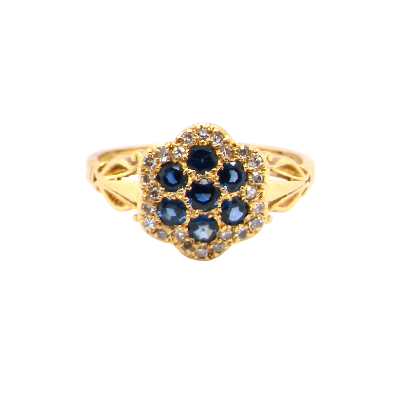 An 18 carat gold cluster ring. The centre a floral combination of seven sapphires, each 2.5mm, mid to dark blue.