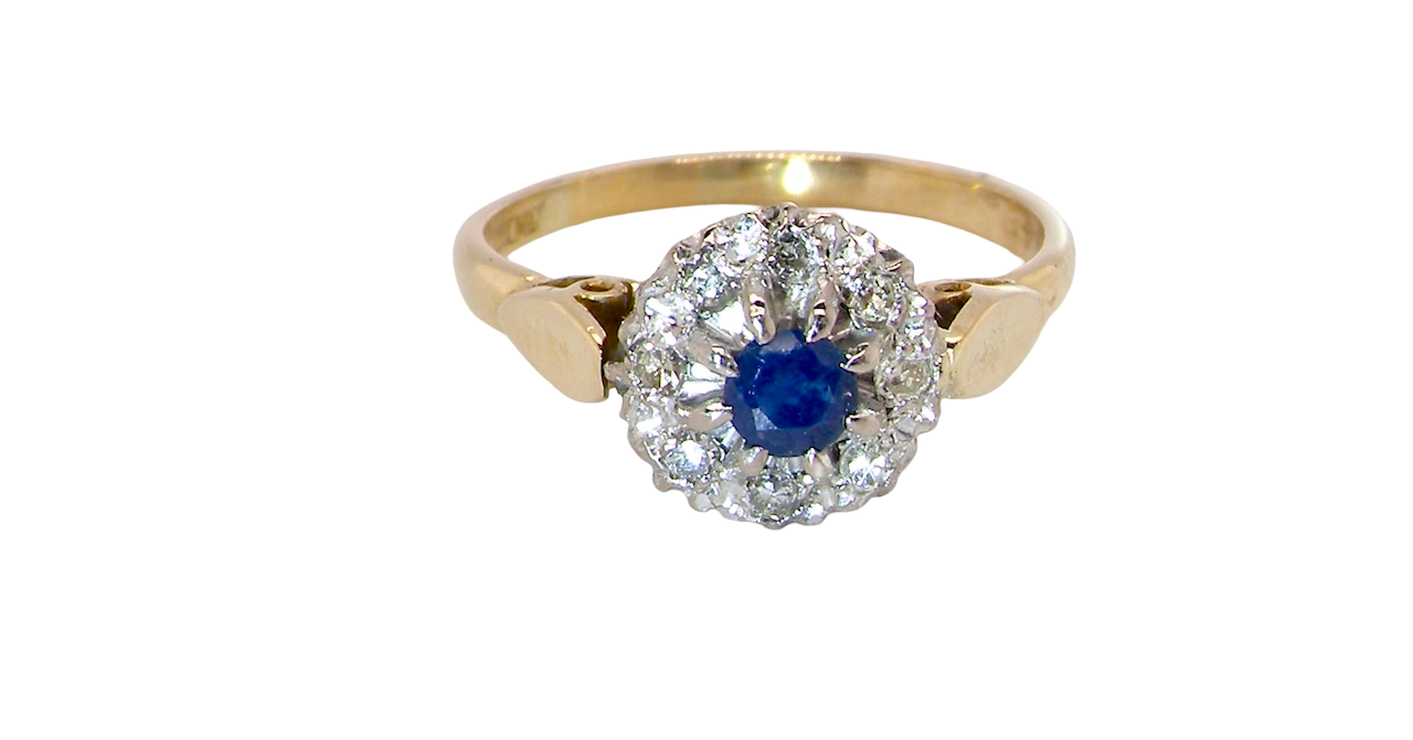 An 18 carat gold cluster ring, features to the centre a dark blue sapphire,. Claw set.