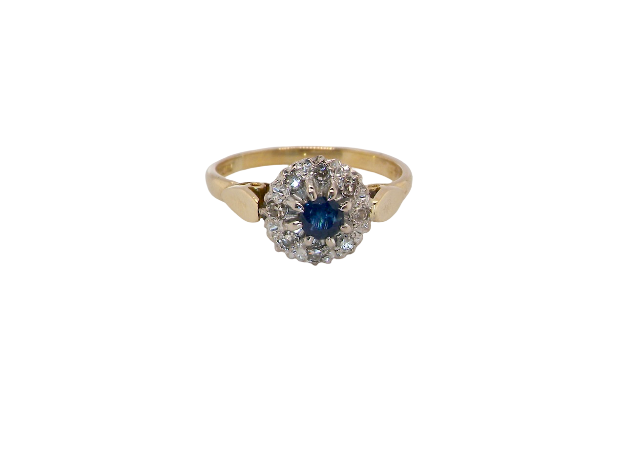An 18 carat gold cluster ring, features to the centre a dark blue sapphire, 3.6mm diameter. Claw set.