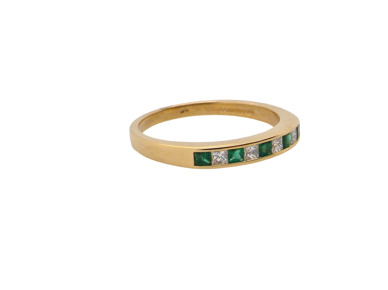 An 18 carat gold emerald and diamond eternity ring