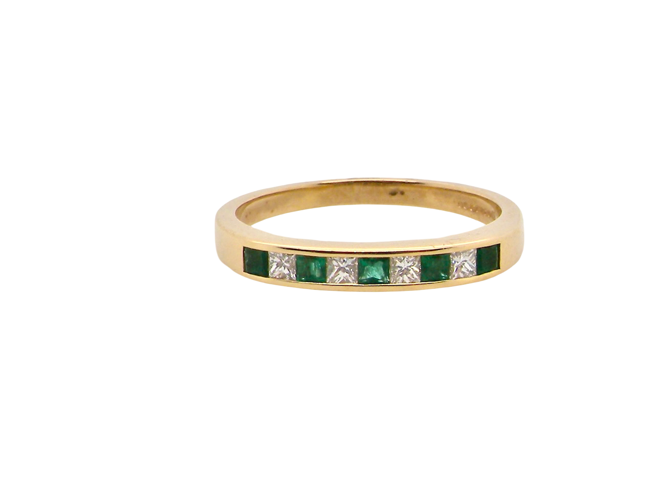 Gold ring with emeralds and diamonds on a white background