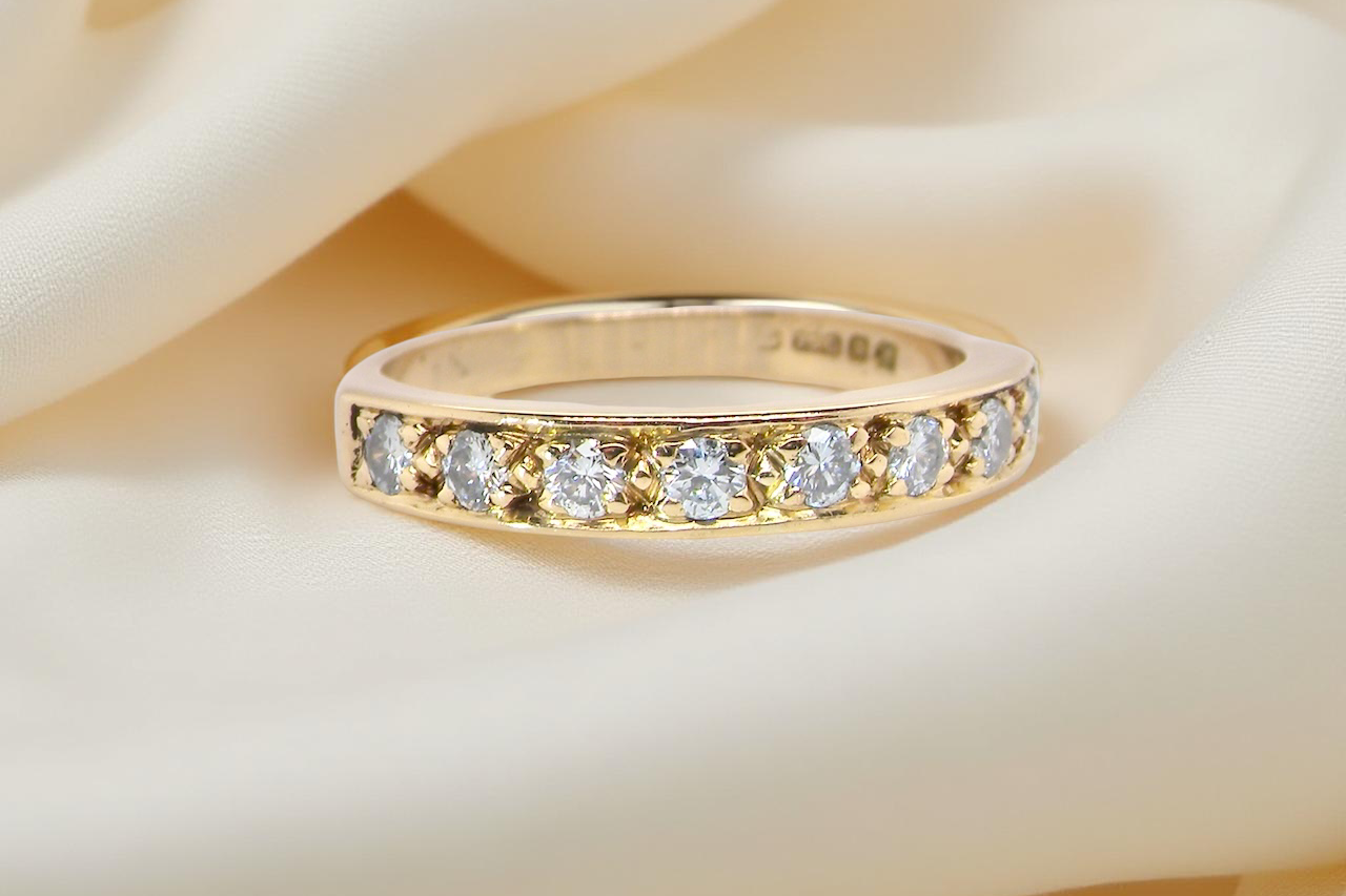 An 18 carat gold half-hoop eternity ring, set with eight white diamonds