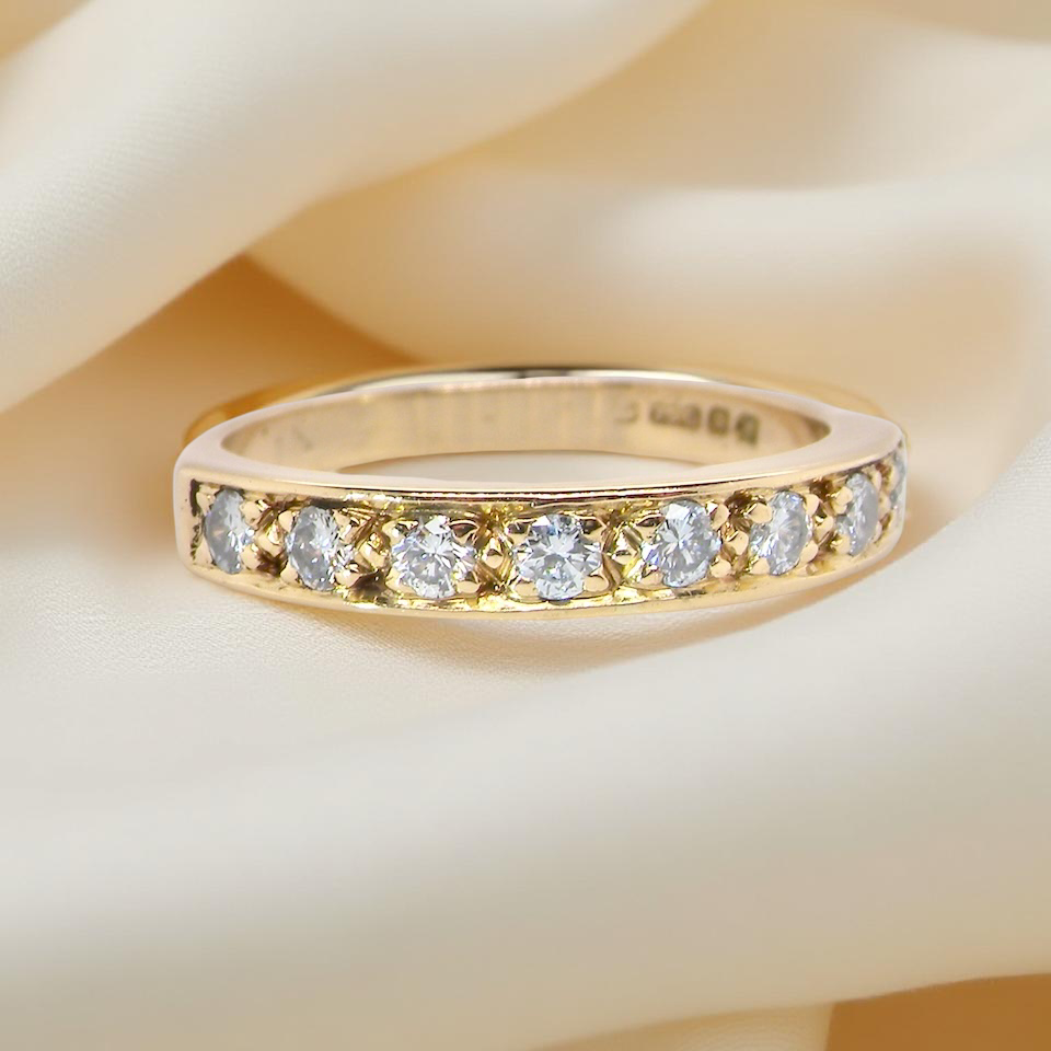 An 18 carat gold half-hoop eternity ring, set with eight white diamonds