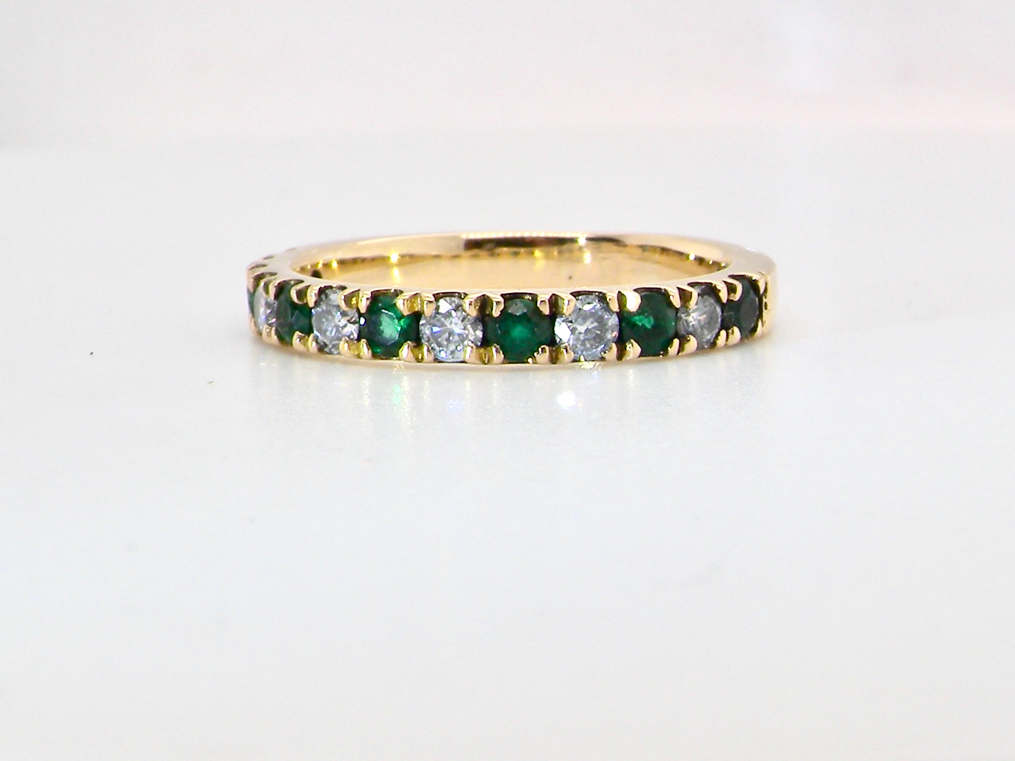 An 18 carat gold half-hoop eternity ring, with six round-cut emeralds