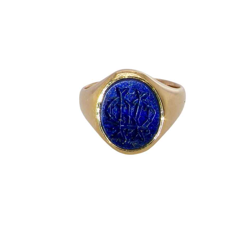 An 18 carat gold signet ring set with an oval lapis lazuli stone. This measures 12x9.5mm and has a carved intaglio seal engraved onto the stone. (These seem to be floral patterns)