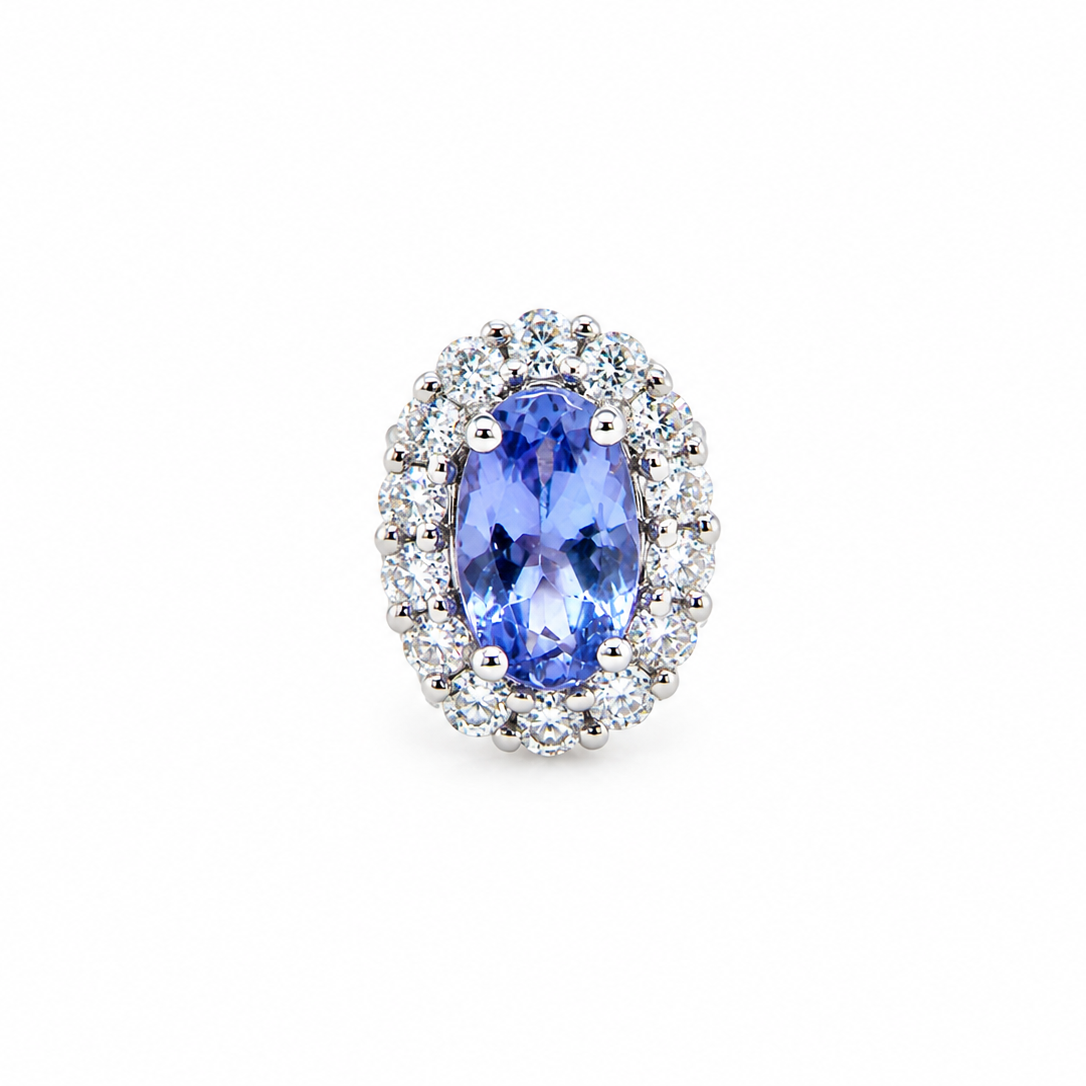 An oval halo ring featuring a central blue tanzite gemstone surrounded by a double halo of small clear round diamonds in a silver-colored setting, isolated on a white background.