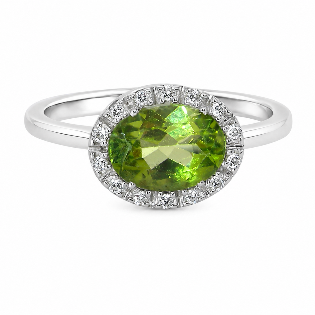 An 18 carat white gold* cluster ring. Features and oval shaped peridot gemstone, measures 8.5x6.5mm.
