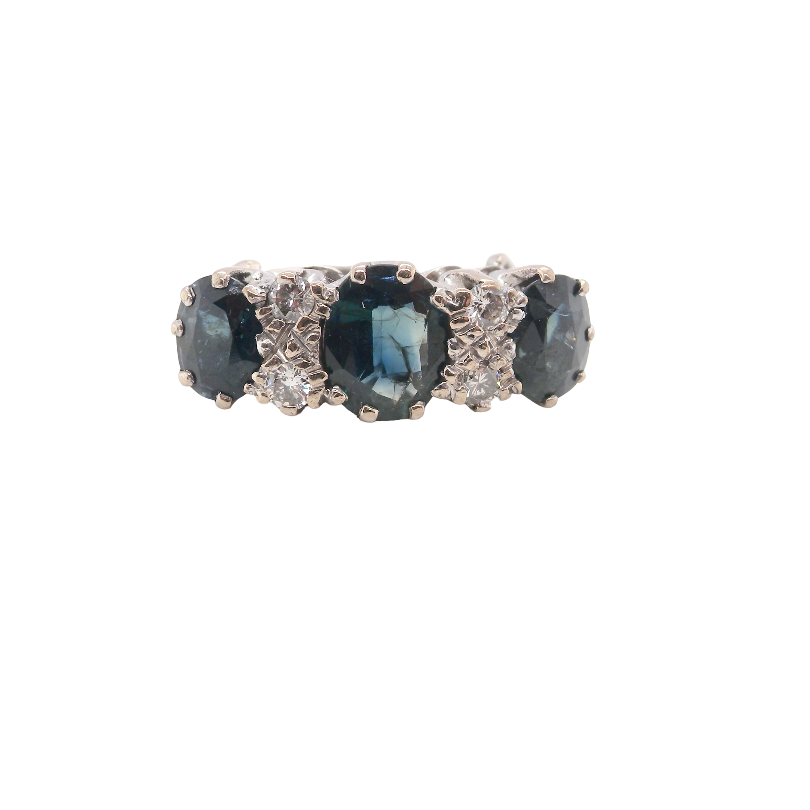 An 18 carat white gold * dress ring. Features three large sapphires, centre 8x6mm (est 1.25 carats) and each side a 7x5mm sapphire (est 0.75 carats), dark blue hues,
