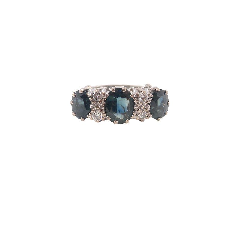 An 18 carat white gold * dress ring. Features three large sapphires, centre 8x6mm (est 1.25 carats) and each side a 7x5mm sapphire (est 0.75 carats), dark blue hues, with slight green tinges to edges.