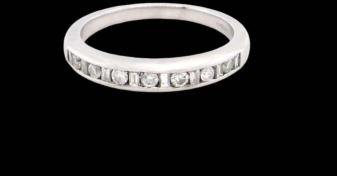 An 18 carat white gold half hoop eternity ring. Mixed cuts of white diamonds which consist of seven round brilliant stones, each 2mm diameter and eight baguette cut stones,