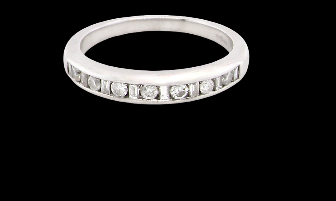 An 18 carat white gold half hoop eternity ring. Mixed cuts of white diamonds which consist of seven round brilliant stones, each 2mm diameter and eight baguette cut stones,