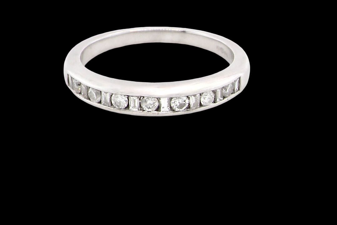 An 18 carat white gold half hoop eternity ring. Mixed cuts of white diamonds which consist of seven round brilliant stones, each 2mm diameter and eight baguette cut stones,