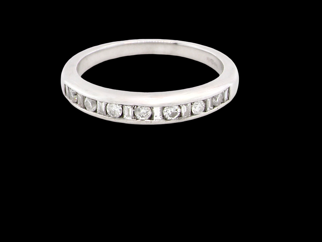An 18 carat white gold half hoop eternity ring. Mixed cuts of white diamonds which consist of seven round brilliant stones, each 2mm diameter and eight baguette cut stones,