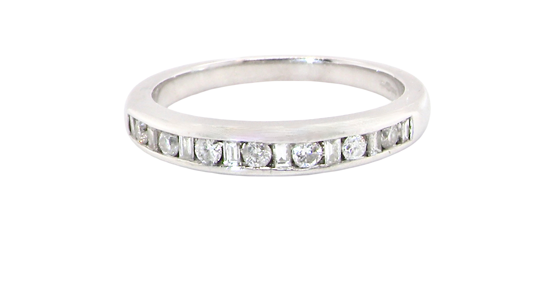 An 18 carat white gold half hoop eternity ring. Mixed cuts of white diamonds which consist of seven round brilliant stones, each 2mm diameter and eight baguette cut stones, each 2x1.5mm.