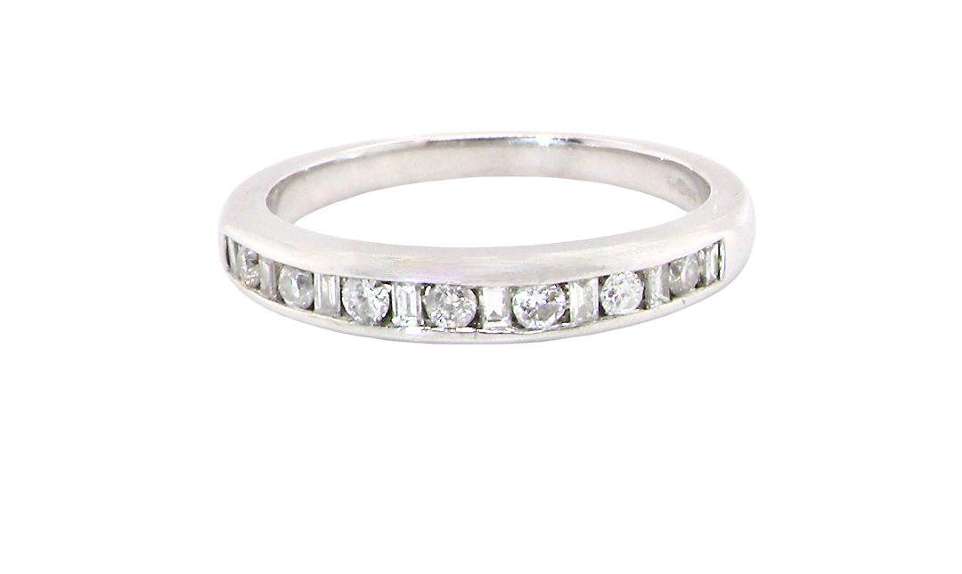 An 18 carat white gold half hoop eternity ring. Mixed cuts of white diamonds which consist of seven round brilliant stones, each 2mm diameter and eight baguette cut stones, each 2x1.5mm.