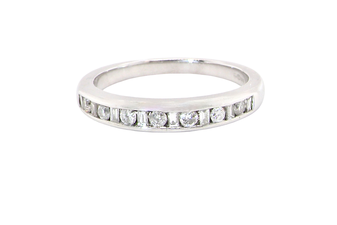 An 18 carat white gold half hoop eternity ring. Mixed cuts of white diamonds which consist of seven round brilliant stones, each 2mm diameter and eight baguette cut stones, each 2x1.5mm.