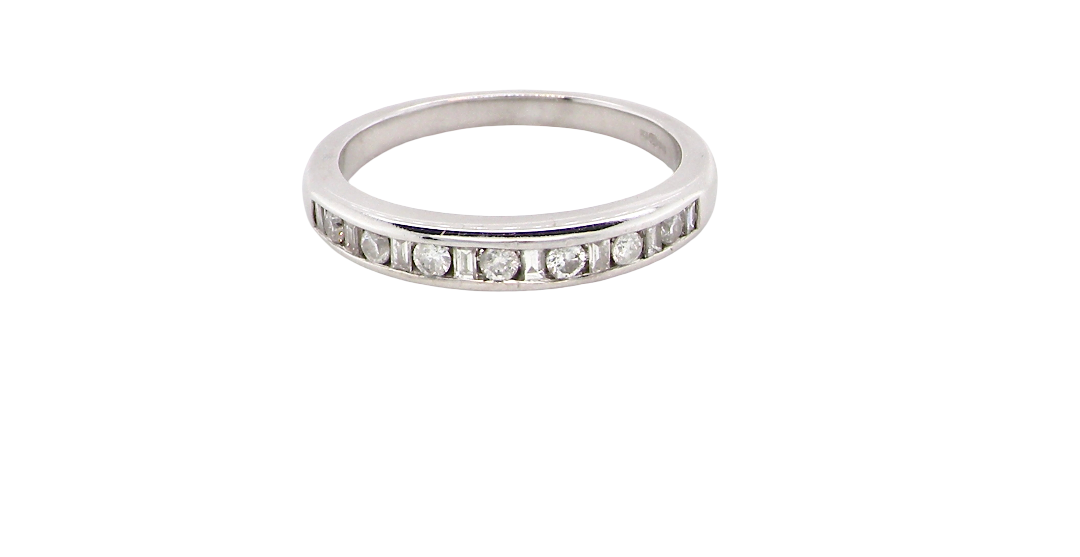 An 18 carat white gold half hoop eternity ring. Mixed cuts of white diamonds which consist of seven round brilliant stones, each 2mm diameter and eight baguette cut stones, each 2x1.5mm. Estimated total 0.50 carats.