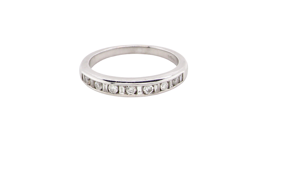 An 18 carat white gold half hoop eternity ring. Mixed cuts of white diamonds which consist of seven round brilliant stones, each 2mm diameter and eight baguette cut stones, each 2x1.5mm. Estimated total 0.50 carats.