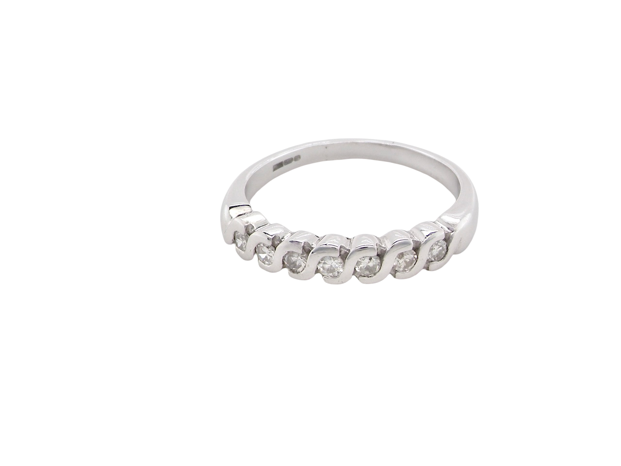 An 18 carat white gold half hoop eternity ring. Set with seven brilliant cut white diamonds,